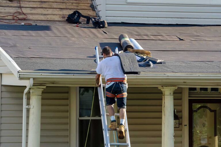 Roofing workers install shingles above a clean, insulated attic with visible ventilation channels.